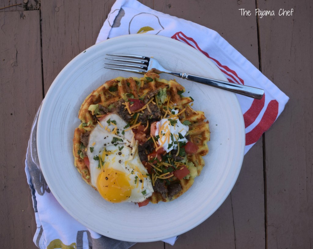 Cornbread waffles filled with cheese, peppers, and onions are loaded with sausage, tomatoes, a creamy avocado spread, and a fried egg for an impressive brunch like no other! This is a fantastic restaurant-worthy dish that's easy to make at home. You'll be sure to love it! #secretrecipeclub